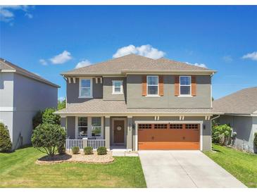 Charming two-story home with a well-manicured lawn, inviting front porch, and a convenient two-car garage at 1856 Castleton Dr, St Cloud, FL 34771