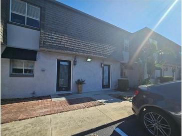 Townhouse exterior features well-maintained stucco, covered entries and tidy brick and concrete walkways at 1920 Conway Rd # 4, Orlando, FL 32812