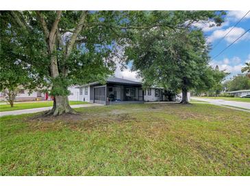 Charming single-story home with large trees, a screened porch and well-manicured lawn on a corner lot at 2 S Lavon Ave, Kissimmee, FL 34741