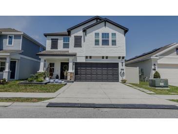 Charming two-story home featuring a two-car garage, stylish shutters, and manicured landscaping at 466 Cool Summer Ln, Davenport, FL 33837
