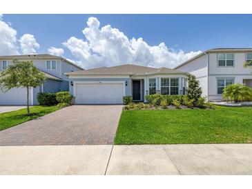 Charming single-Gathering home with a well-manicured lawn, brick driveway, and beautiful landscaping at 5648 Cedar Chase Dr, St Cloud, FL 34771