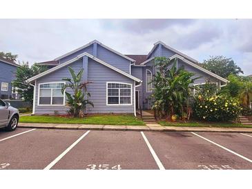 Charming condo with blue siding, white trim, well-maintained landscaping, and designated parking at 658 Caribbean Dr, Davenport, FL 33897