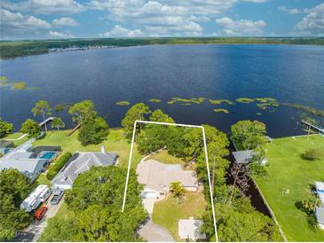 Expansive aerial view of the lakefront home with lush greenery and stunning lake views at 1186 Laguna Cir, St Cloud, FL 34771
