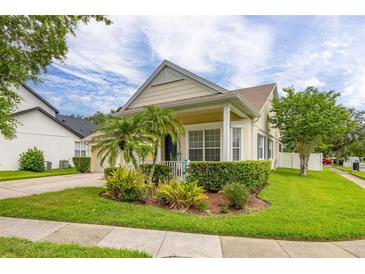 Charming home with manicured lawn, lush landscaping, and a welcoming front porch at 14167 Bradbury Rd, Orlando, FL 32828