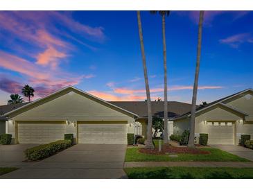 Charming one-story home with well-manicured lawn and three palm trees providing a pleasant, tropical feel at 168 Club Villas Ln, Kissimmee, FL 34744