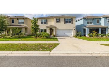 Two-story home featuring a well-manicured lawn, a two-car garage, and neutral colored paint at 176 Sofia Ln, Lake Alfred, FL 33850