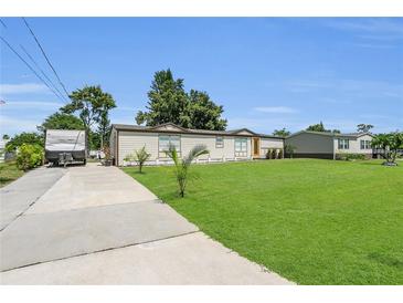 Charming single-story home with well-maintained lawn and long driveway on a sunny day at 3173 Wake Up Ct, Kissimmee, FL 34744