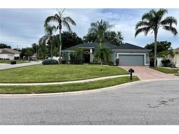 Single story home featuring a well manicured lawn and mature landscaping with palm trees at 3901 Ballinore Pl, Gotha, FL 34734