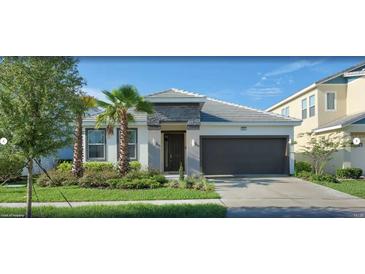 Charming single-Gathering home featuring a lush lawn, gray roof, and an attached two-car garage at 4504 Monado Dr, Kissimmee, FL 34746