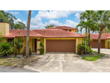 Charming single-story home with a terracotta roof, lush landscaping, and a two-car garage at 5015 Nassau Cir # 4, Orlando, FL 32808
