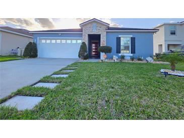 Charming single-story home with well-manicured lawn and stone accents at 585 Lucerne Blvd, Winter Haven, FL 33881