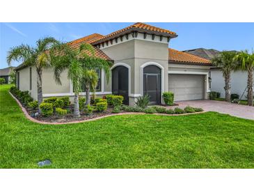 Charming home with lush landscaping, well-maintained lawn, and a tile roof at 605 San Augusto Dr, Kissimmee, FL 34759