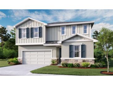 Charming two-story home with blue shutters, stone accents, landscaped yard, and an attached two-car garage at 6167 Daphne St, Lake Hamilton, FL 33851