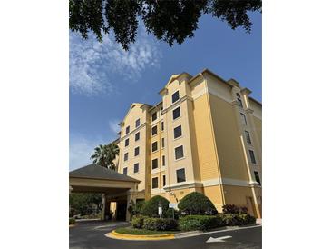 Hotel exterior featuring a covered entrance, manicured landscaping, and architectural details at 7601 Canada Ave, Orlando, FL 32819