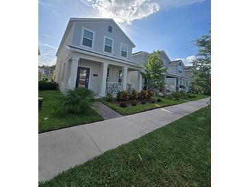 Charming two-story home with covered porch, landscaped yard, and beautiful neighborhood views at 11328 Listening Dr, Orlando, FL 32832