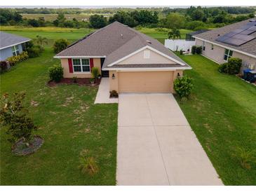 Charming single-story home featuring a well-manicured lawn and an attached two-car garage at 1158 Legatto Loop, Dundee, FL 33838