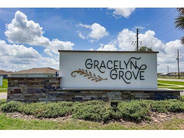 Gracelyn Grove community sign with stone base and lush landscaping against a partly cloudy sky at 1719 Daystar Dr, Haines City, FL 33844