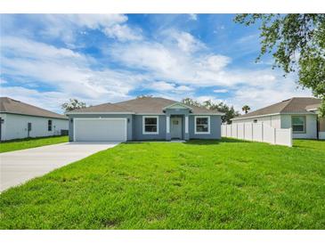 Charming single-story home featuring a well-manicured lawn and a classic two-car garage at 4615 Madison Ave, Lake Wales, FL 33859