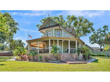 Charming two-story home with a large porch, columns, mature trees, and manicured landscaping at 822 W Patterson St, Lakeland, FL 33803