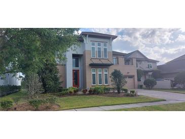 Beautiful home featuring manicured landscaping and a red front door at 9414 Haber Ct, Orlando, FL 32827