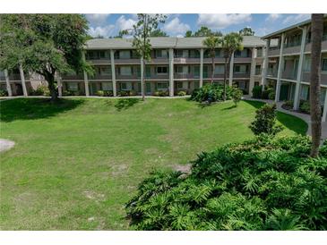 Beautiful condo community with lush green lawn, mature trees, and well-maintained building exterior at 139 Oyster Bay Cir # 200, Altamonte Springs, FL 32701