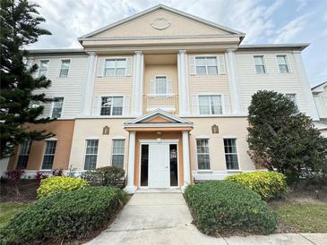 Stylish condo exterior features white columns, well-maintained landscaping, and a welcoming entrance at 1592 Heritage Crossing Ct # 202, Reunion, FL 34747
