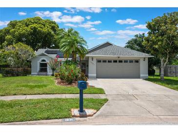 Charming single-story home features a well-maintained lawn, beautiful landscaping, and a two-car garage at 1631 Woodbay Ct, Kissimmee, FL 34744