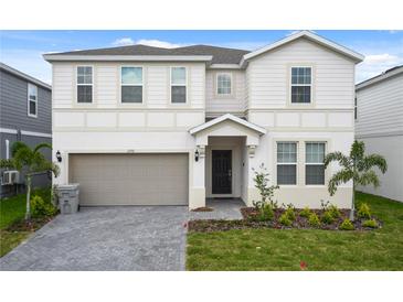 Charming two-story home featuring a two-car garage, well-maintained lawn, and welcoming front entrance at 2176 Lelani Cir, Davenport, FL 33897