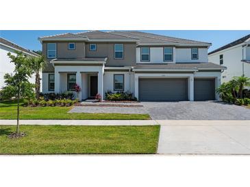Charming two-story home featuring a two-car garage, a landscaped front yard, and an elegant entryway at 2397 Shanti Dr, Kissimmee, FL 34746