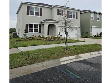 Two story home with a two car garage, manicured lawn, and a well maintained landscape at 3886 Whitney Way, Haines City, FL 33844