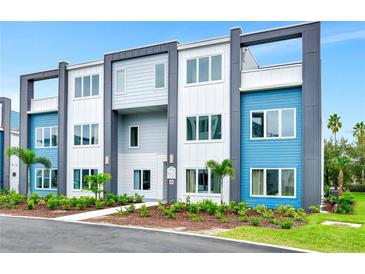 Modern three-story townhome featuring colorful facades and manicured landscaping for enhanced curb appeal at 7770 Sandy Ridge Dr # 142, Kissimmee, FL 34747