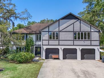 Charming multi-story home boasting a three-car garage, manicured lawn, and architectural details at 11951 Elbert St, Clermont, FL 34711