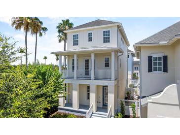 Charming two-story home with a double balcony, stucco siding, and a beautiful landscaped yard at 1379 Kiawah St, Celebration, FL 34747