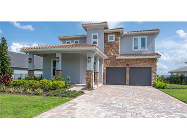 Stunning two-story home with a brick driveway, a covered porch, and a two-car garage at 15600 Vetta Dr, Bella Collina, FL 34756