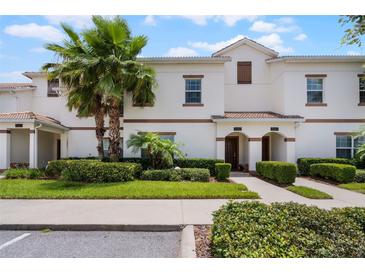 Inviting townhome exterior with well-manicured landscaping and a charming tile roof at 1565 Plunker Dr, Davenport, FL 33896