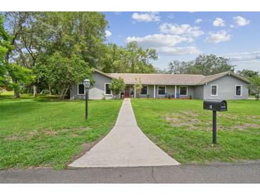 Charming single story home with a well manicured lawn and inviting walkway to the front door at 16 Pine Forest Dr, Haines City, FL 33844
