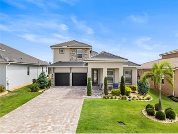 Beautiful two-story home featuring a manicured lawn and a spacious two-car garage at 16049 Volterra Pt, Bella Collina, FL 34756