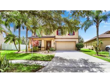 Charming home featuring mature trees, a two-car garage, and a well-maintained lawn at 2722 Corybrooke Ln, Kissimmee, FL 34744