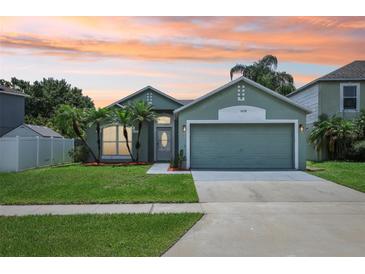 Charming single-story home with a well-manicured lawn and tropical palm trees against an orange sunset sky at 3038 Elbib, St Cloud, FL 34769