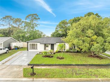 Beautifully landscaped single-story home with fresh exterior paint, manicured lawn, and a modern driveway at 3804 Anthony Ln, Orlando, FL 32822