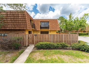 Charming townhome featuring a fenced yard, balcony, and well-maintained landscaping and beautiful blue sky at 5251 Brook Ct # 242, Orlando, FL 32811