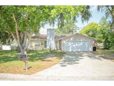 Charming single-story home with a lush, tree-filled yard and a classic two-car garage at 7410 Orange Crest Cir, Lakeland, FL 33810