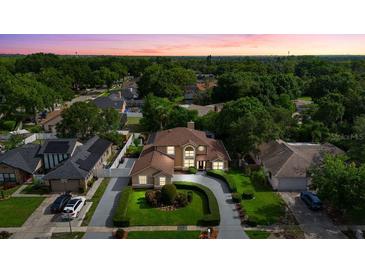 Beautiful two-story home featuring a meticulously landscaped front yard and circular driveway at 7846 Snowberry Cir, Orlando, FL 32819