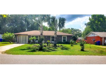Charming single-story home with well-maintained landscaping and inviting curb appeal on a sunny day at 505 Oak Dr, Tavares, FL 32778