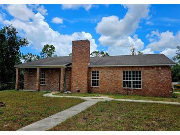 Charming brick home with a well-maintained lawn, blue skies and a prominent brick chimney at 600 Lake Butler Ave, Osteen, FL 32764