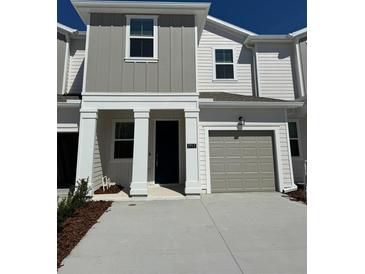 Inviting two-story townhome with gray accents and a one car garage at 7717 Stone Creek Trl, Kissimmee, FL 34747