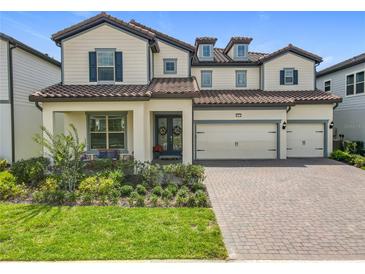 Charming two-story home with lush landscaping, a tile roof, and a three-car garage at 9071 Woodland Forest Rd, Orlando, FL 32836