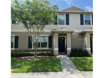 Charming townhome featuring a well-manicured lawn and a welcoming entrance at 1868 Katz Crossing Dr, Kissimmee, FL 34744