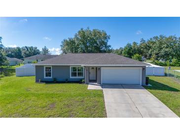 Charming single-story home with well-manicured lawn, attached garage, and neutral gray paint at 10 Pine Track Trl, Ocala, FL 34472
