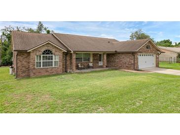 Charming brick home featuring a well-manicured lawn and a cozy front porch with seating at 1063 Fountainhead Dr, Deltona, FL 32725